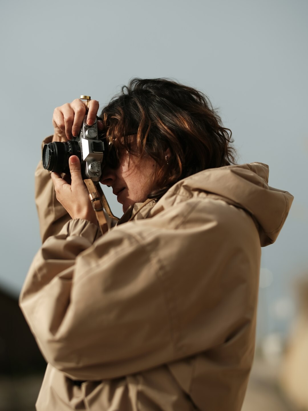 Young female photographer holding a camera outdoors